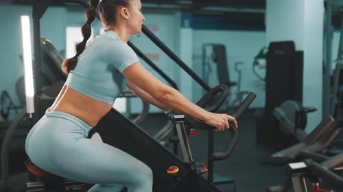 Woman exercising on stationary bike in gym