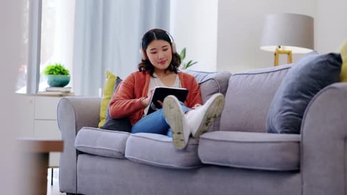 Tablet, Kopfhörer und Frau entspannen sich auf der Couch mit Musik-Streaming-App und sozialen Medien