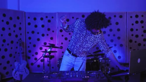 Cool african man DJ dancing while mixing new album inside recording studio - Technology and music