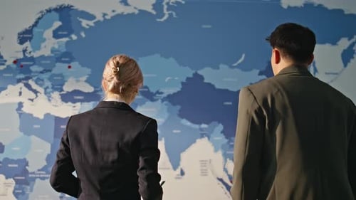 Geschäftsleute diskutieren über die Weltwirtschaft und schauen sich die Kollegen von Estimating Map Two an