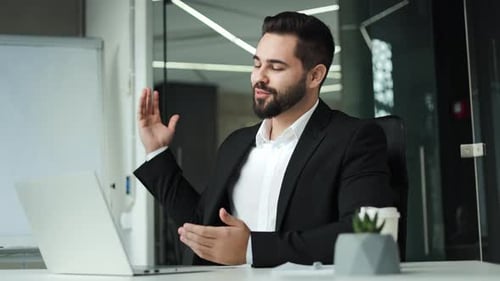 Successful Boss Waving Hello While Conducting Online Meeting in Modern Office