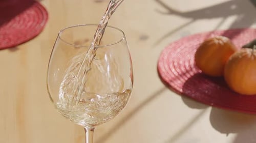 Pouring White Wine into Glass at Table