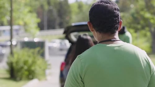 Volunteers Unloading Paint Cans for Recycling in Parking Lot Altruism