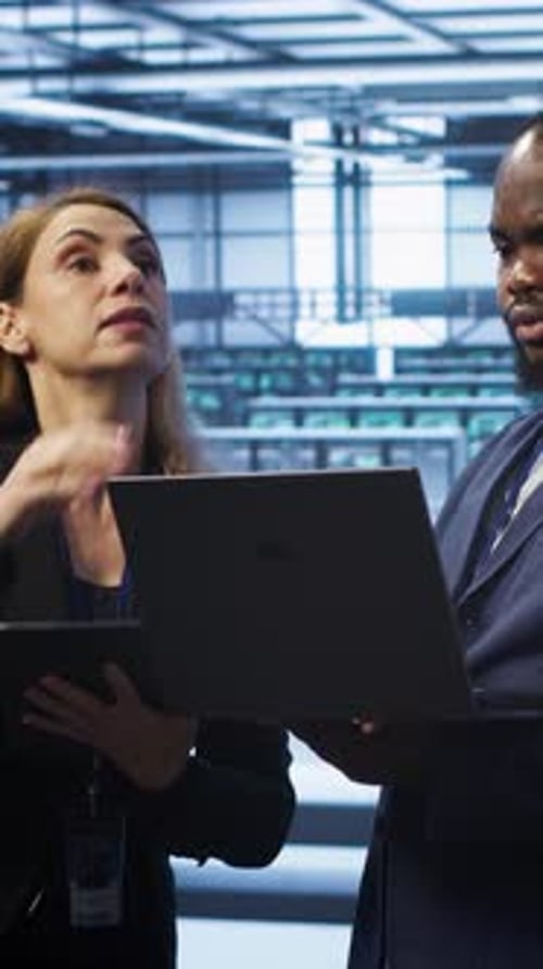 Vertical Video Supervisor in Server Farm Overseeing Engineer Fixing Network Issues