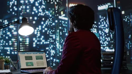 Adult Working at Night in Office with Data