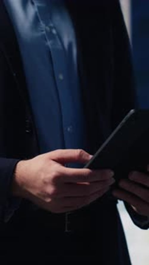 Man Uses Tablet in Front of Office Screens