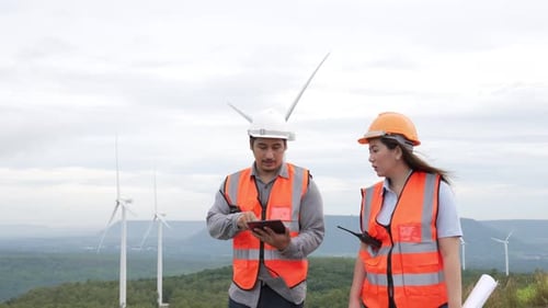 Progressive Concept of Engineers Working in the Wind Farm Atop of the Mountain