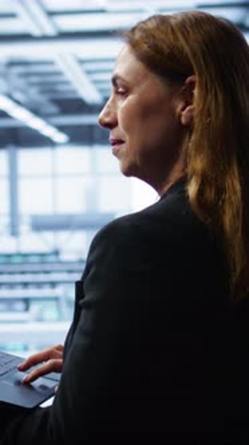 Vertical Video Smiling IT Expert Uses Notebook in Data Center Workspace