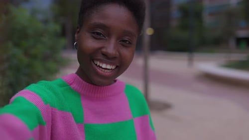 African Woman Having a Video Call with Friend Using Mobile Phone App at City