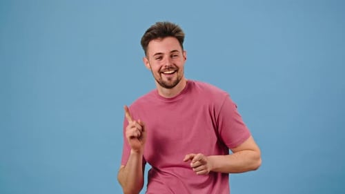 Man Dancing and Smiling Against Blue Background