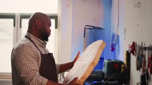 Portrait of Smiling Carpenter in Woodworking Shop Inspecting Wood Block