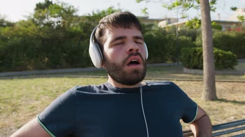 Young Adult Relaxing on Bench with Headphones