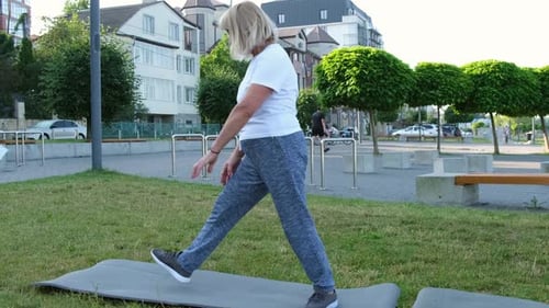Beautiful Grandmother Doing Fitness Exercises in the Park Sports Life in Retirement