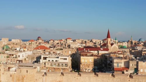 Hot air balloon passing over Acre old city port houses and Mosque at sunrise, Aerial view