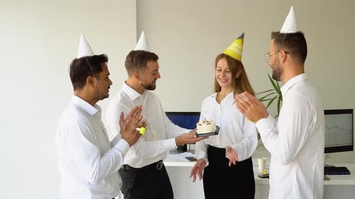 Young Female Office Worker is Blow Candles on Cake and Make a Wish While Celebrating Birthday with