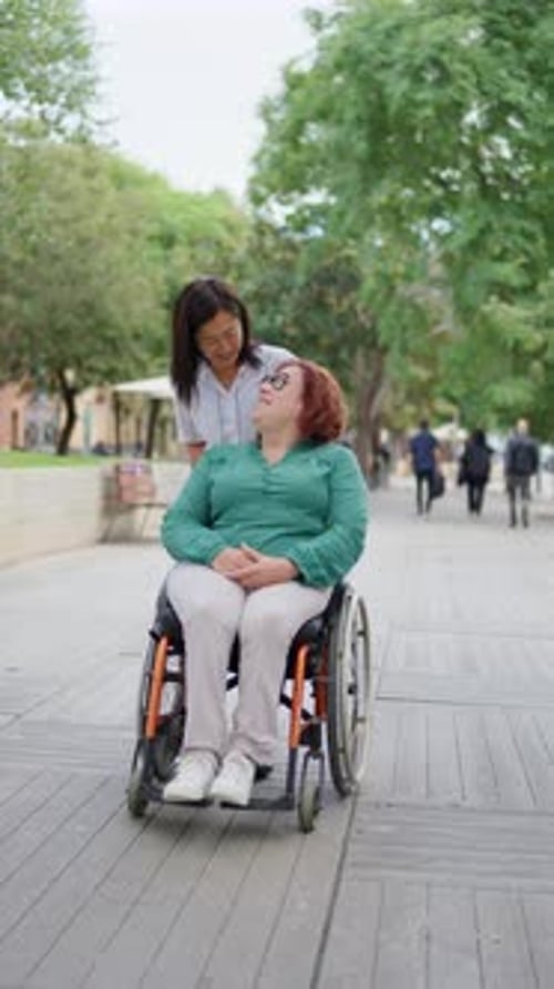 Woman in Wheelchair with Friend in Urban Park