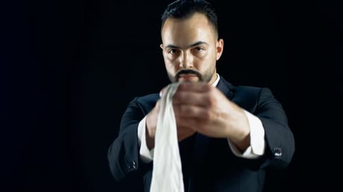 Man in Suit Manipulating White Cloth Close Up