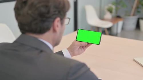 Close Up of Businessman Holding Smartphone with Green Screen
