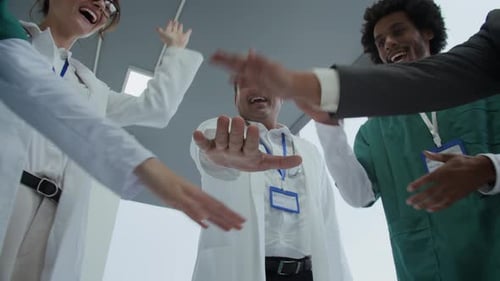Multiethnic Doctors Celebrating Success after Operation in Hospital