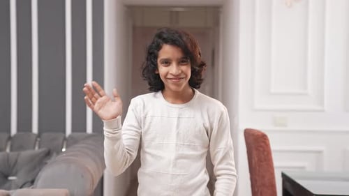 Indian kid teenager boy waving hand and saying hello