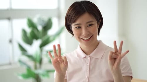 Woman Smiling and Counting With Fingers Indoors