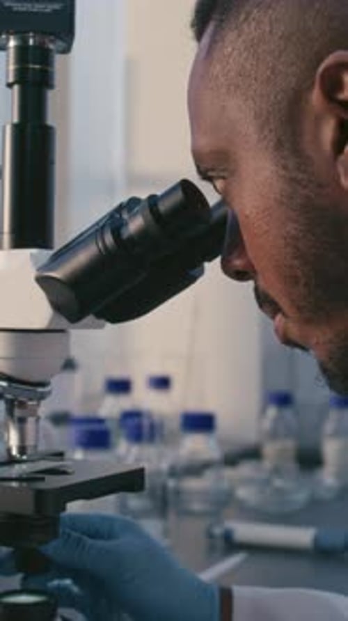 Close Up of Scientist Using Microscope in Lab