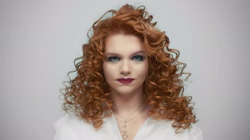 Beautiful Woman with Red Curly Hair Shakes Her Head