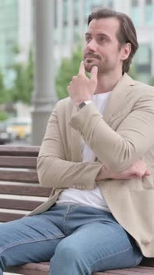 Pensive Young Man Thinking while Sitting on Bench, Vertical Video