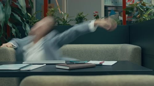 Woman Flailing On Couch In Office Setting