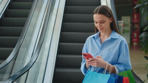 Woman Using Phone While Shopping at Mall