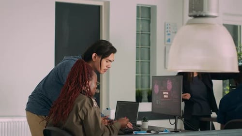 Colleagues Collaborating on Code in Bright Office