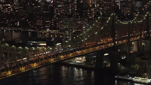 Cars Driving Across the Illuminated Queensboro Bridge at Night Connecting the New York City Boroughs