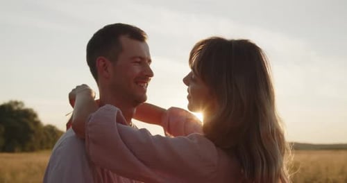 Young Attractive Couple Having a Date at Sunset in a Golden Wheat Field