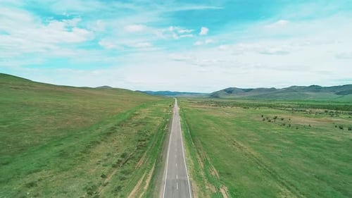 Aerial View of an Asphalt Road Through the Rural Countryside Area Wavy Road Between Little Hills