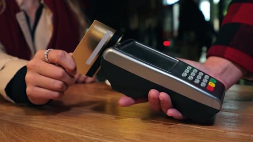 Close Up Video of a Unrecognizable Customer Hand Using a Credit Card for Contactless Payment on a
