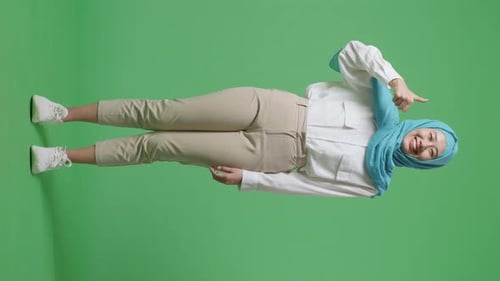 Full Body Of Asian Muslim Woman Smiling And Showing Thumbs Up Gesture In The Green Screen