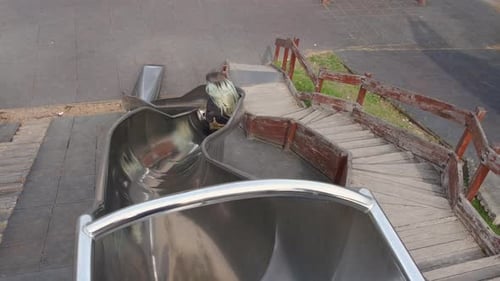 Sliding Teen on Playground in Day