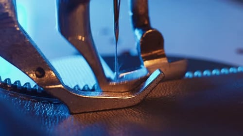 The leather craftsman produces leather products on sewing machine.Close-up of the sewing machine nee