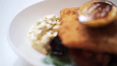 Gros plan d'un filet de poisson pané avec sauce tartare et betteraves cuites au four