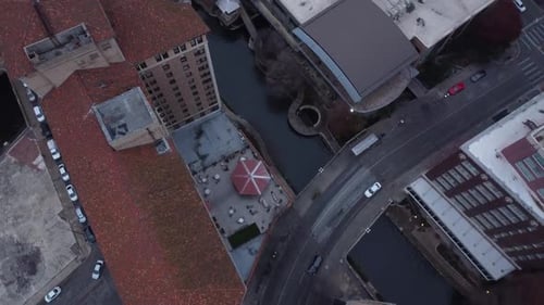 A top-down drone shot over a winding river in the city.