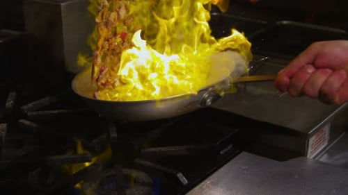 Eine flammende Bratpfanne entfacht die Sinne in einer kulinarischen Darbietung in Zeitlupe