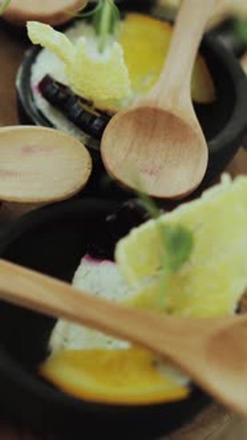 Vidéo présentant une table remplie de bols de plats délicieux et de cuillères en bois dressées pour un repas