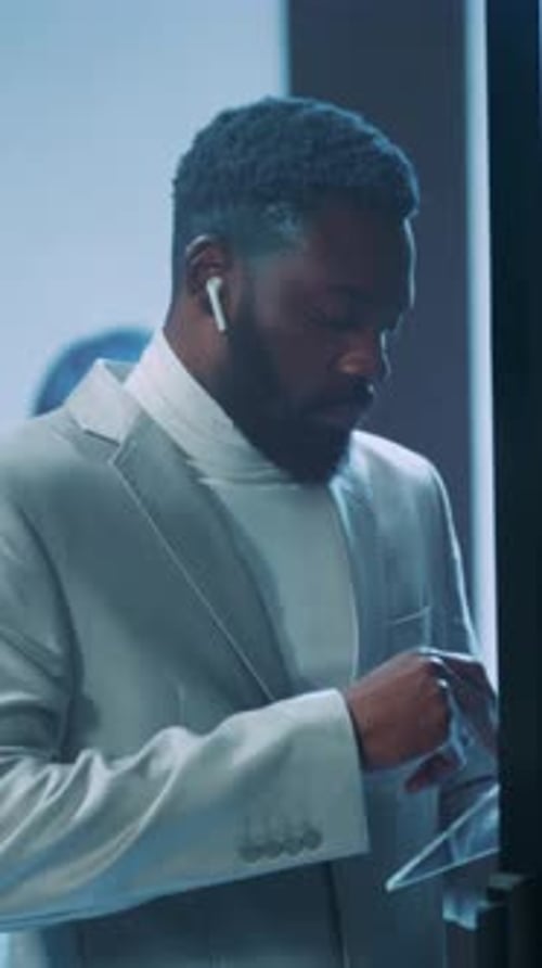 Man in Gray Suit Using Touchscreen in Server Room