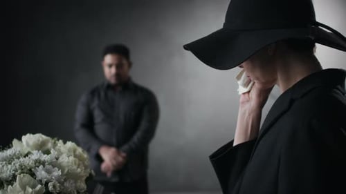 Woman in Hat Cries at Funeral Coffin