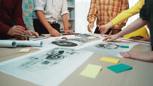 Diverse Team Collaborating Over Engineering Blueprints in Office