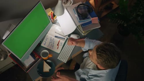 Man Eating Sandwich at Desk with Green Screen