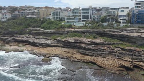 Waves Splashing On Rocky Coast At Tamarama Point In Sydney, New South Wales. aerial sideways