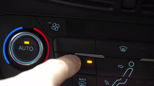 Finger turning on toggle switch of car air conditioner, two-phase climate control in the car