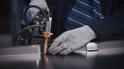 A Factory Worker Uses Spot Welding to Join Steel Parts The Process of Manufacturing Steel Products