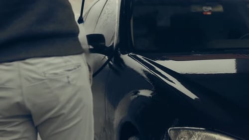 Dark Car Being Pressure Washed at Carwash